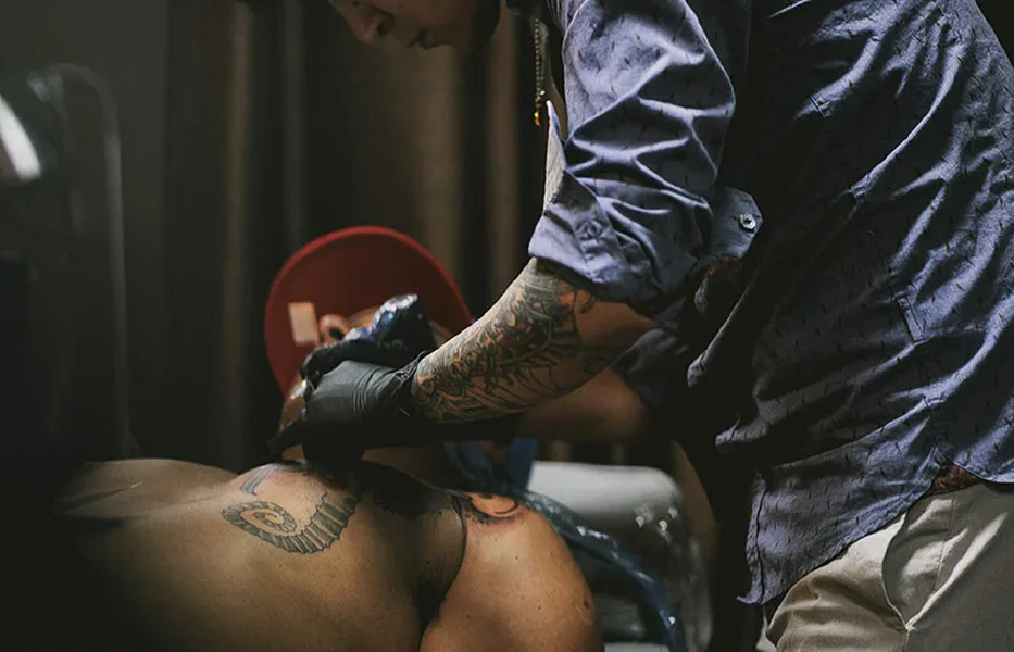 Tattoo artist at work representing the main service areas highlighted on the site.